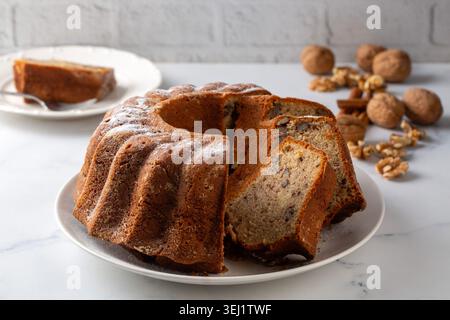 Homemade Cinnamon Walnut Bundt Cake Sliced on a White Plate Stock Photo