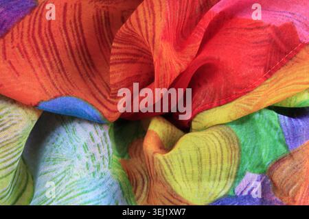 Vibrant rainbow abstract floral silk scarf with bold, energetic leaf patterns in fiery colors Stock Photo