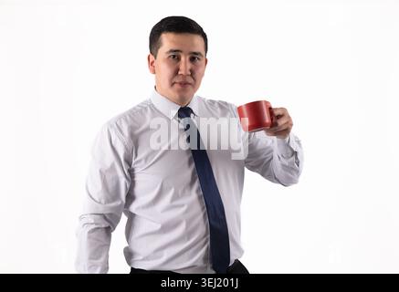 Young man drinking hot beverage from a red mug Stock Photo