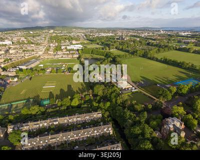 Aerial view of lush green sports fields and historic terraced houses under a soft cloudy sky in Edinburgh, Scotland, United Kingdom. Stock Photo