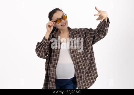 Young pregnant woman posing with sunglasses in studio Stock Photo