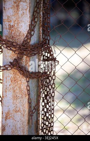 Closeup of aged rusty chain and peeling paint in industrial environment Stock Photo