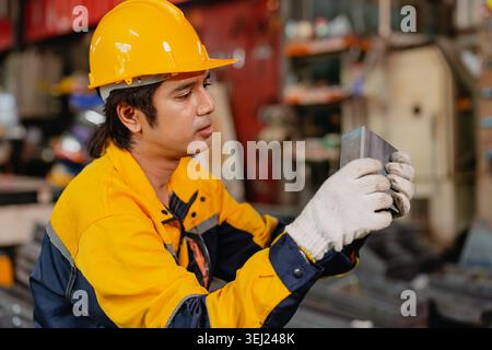 Professional worker man working in metal part workshop, Quality control staff looking product part to verify the accuracy of the workpiece. Stock Photo