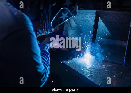 Workshop worker man welding, Welder in metal part industry, Garage metalwork technician hand making steel part using Tungsten Inert Gas welding Stock Photo
