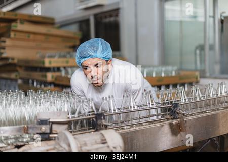 Food and drinks Industry man working. Line product Visual Inspection in factory for food safety quality control worker. Stock Photo