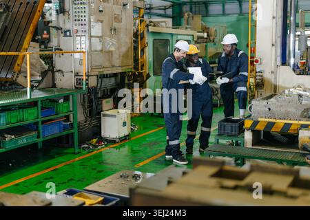 Happy relax Engineer team workers talking together laughing smiling in heavy industry factory plant Stock Photo