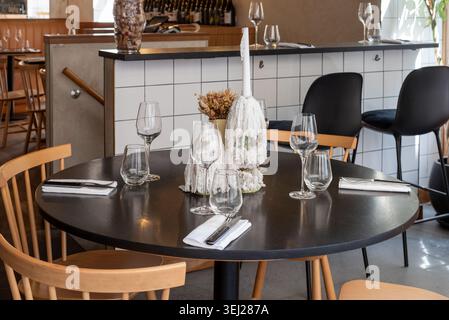 Closeup of a table setting in a restaurant in Paris. A dripping candle in the middle of a simple table setting. Stock Photo
