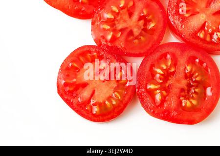 Fresh tomato slices isolated on white background. Healthy vegetable ingredient and natural food concept for cooking and nutrition. Stock Photo