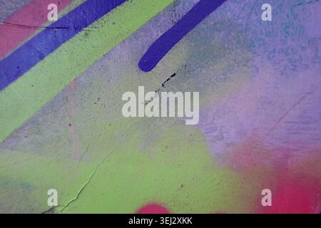 Abstract painted wall with random brush strokes and spray lines in purple pink blue neon green palette Stock Photo