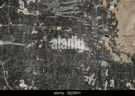 Dark grunge wall texture background with rough black surface and beige plaster area, abstract distressed composition, copy space, horizontal. Stock Photo