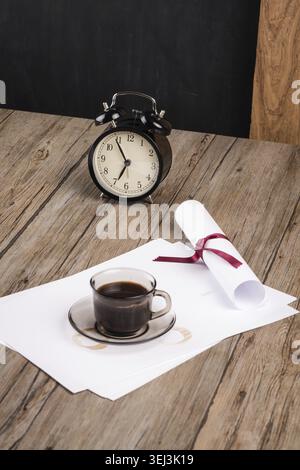 Old clock, hat, coffee and paper sheets on old Wooden table Stock Photo