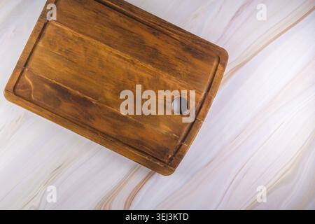 Rectangular shaped wood cutting board on dark concrete background. Top view with copy space for text Stock Photo