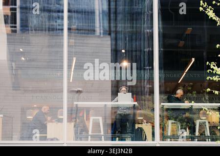 Toronto, Canada - May 12, 2026: People Working and Socializing Inside Toronto Cafe Viewed Through Glass Window Stock Photo