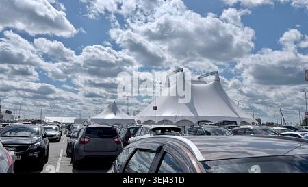 Large white event tent with parking lot under cloudy sky Stock Photo