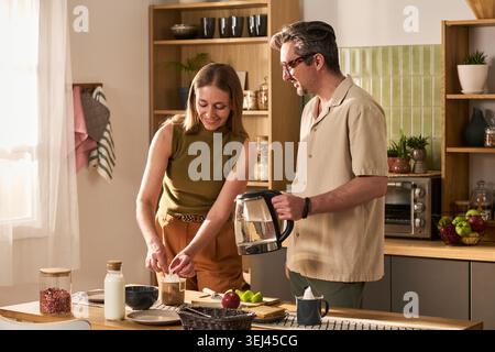 Adult Couple Preparing Breakfast Together in Home Kitchen Stock Photo