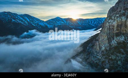 Aerial Mt Charleston Cloud Inversion at Sunset With Sunburst and Snowy Peaks Stock Photo