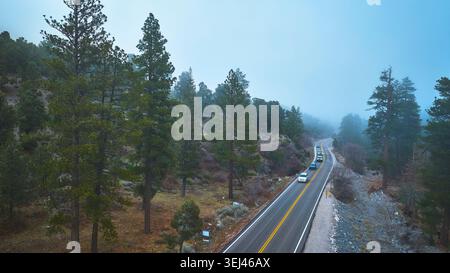 Aerial Mt Charleston Mountain Road with Cars and Pine Forest in Nevada Mist Stock Photo