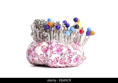 Colored pinheads in pin-cushion isolated on white background Stock Photo