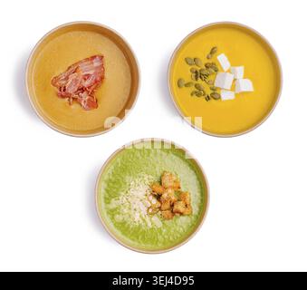 Food, Three bowls of vibrant soups showcase a variety of flavors and textures. The soups include a creamy orange pumpkin, a green spinach with topping Stock Photo
