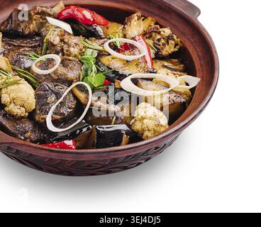 Food, A colorful assortment of grilled meat and vegetables presented in a traditional clay pot. The dish includes eggplant, cauliflower, and spices, p Stock Photo