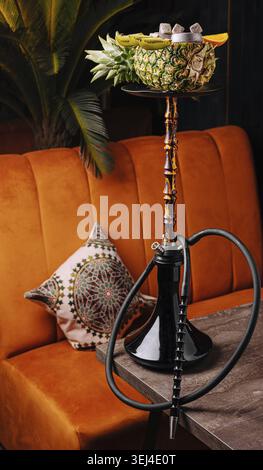 Food, A beautifully crafted hookah sits on a wooden table in a cozy lounge. The hookah is made from a pineapple and features colorful fruits on top, s Stock Photo