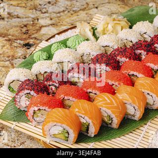 Food, A vibrant sushi platter showcases assorted rolls featuring various toppings like fish and sesame seeds. Beautifully arranged on a bamboo mat, ga Stock Photo