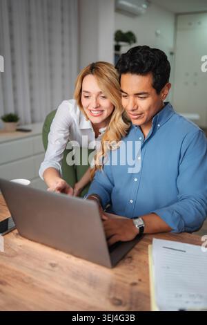 Young couple collaborating on laptop in home office Stock Photo