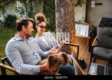 Couple relaxing outdoors with dog using digital tablet Stock Photo