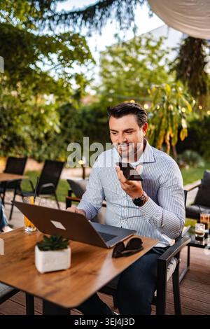 Man working remotely using laptop and voice message Stock Photo