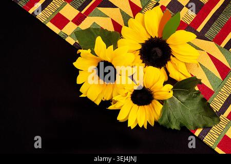 Sunflowers blooming on colorful kente cloth pattern Stock Photo