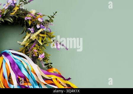 Floral wreath with colorful ribbons on green background Stock Photo