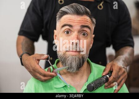 Client reacting to barber services in salon Stock Photo
