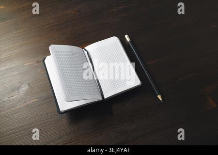 Opened blank notebook and pencil on wood table background. Copy space for text Stock Photo