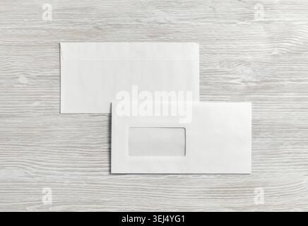 Photo of two blank paper envelopes on light wooden background. Back and front. Flat lay Stock Photo