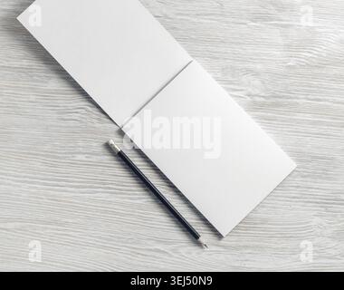 Opened blank notepad and pencil on light wooden background. Flat lay Stock Photo