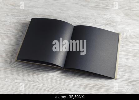 Opened blank black brochure on light wood table background Stock Photo