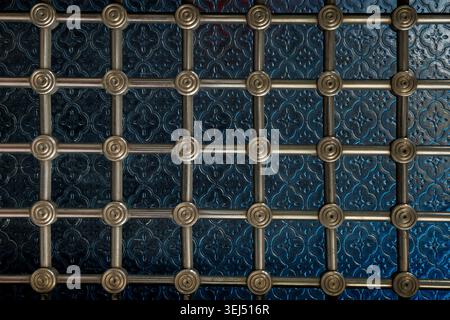 Decorative Metal Grille Over Blue Patterned Surface Stock Photo
