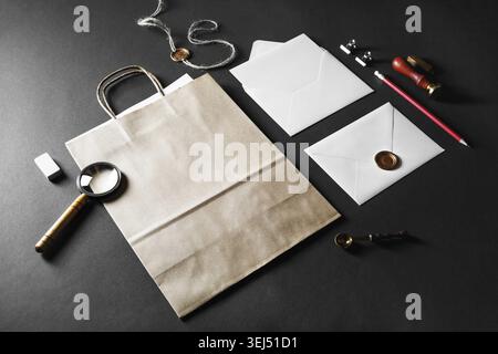 Blank paper bag, envelopes and retro stationery on black paper background Stock Photo