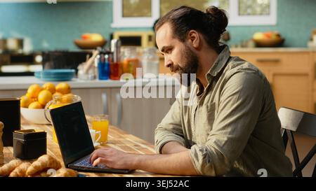 Man engaging with AI-powered chatbot, everyday life use of artificial intelligence, generative software, autonomous and real-time tools, support problem solving and productivity at home. Stock Photo