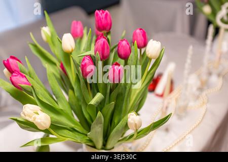 Beautiful Bouquet of Pink and White Tulips on Festive Table Stock Photo
