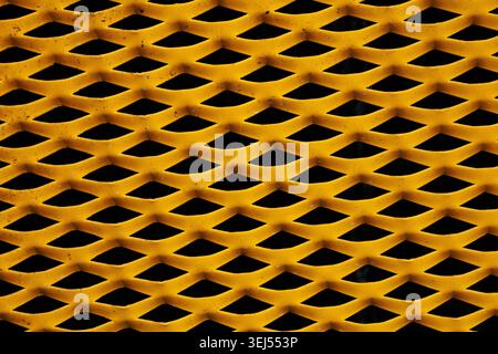 Yellow Expanded Metal Mesh Texture on Black Background Stock Photo