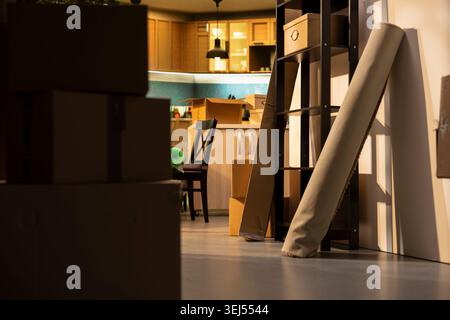 Empty home, stacked boxes, for moving in concept, furniture and belongings, wrapped and packed household items on the floor. New residential property prepared for relocation. Stock Photo