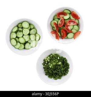 Fresh tomatoes, cucumbers and green onions chopped in salad. Three plates of salad isolated on a white background Stock Photo
