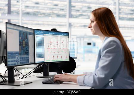 Woman evaluating microchip system architecture blueprints on office desk computer. Female engineer looking at EDA software interface on PC, doing electronic parts design automation Stock Photo