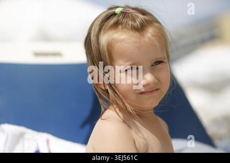 Close-up portrait of a child sunbathing on a sunny day. Shallow depth of field. Focus on the model#39, s face Stock Photo