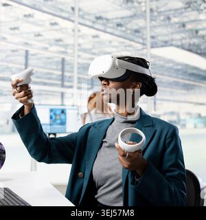 Woman using VR headset gear, analyzing PCB layout in RD office. Employee doing innovative study using virtual reality simulation, researching materials for nanotechnology development Stock Photo