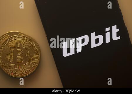 Dhaka, Bangladesh 22 September 2025:Bitcoin coin beside phone with Upbit logo on black background Stock Photo