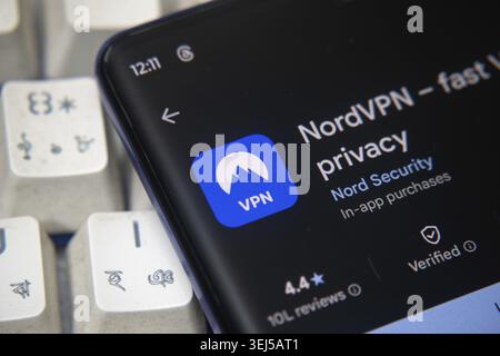 Dhaka, Bangladesh 07 Dec 2025: NordVPN app launch screen with logo on the display of a black mobile smartphone on dark marble stone background. Top vi Stock Photo