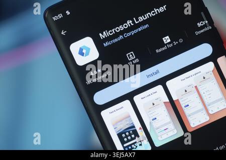 Dhaka, Bangladesh 26 Dec 2025:Smartphone featuring Microsoft Launcher app and earphones against a blue background Stock Photo