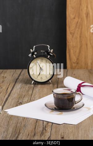 Old clock, hat, coffee and paper sheets on old Wooden table Stock Photo